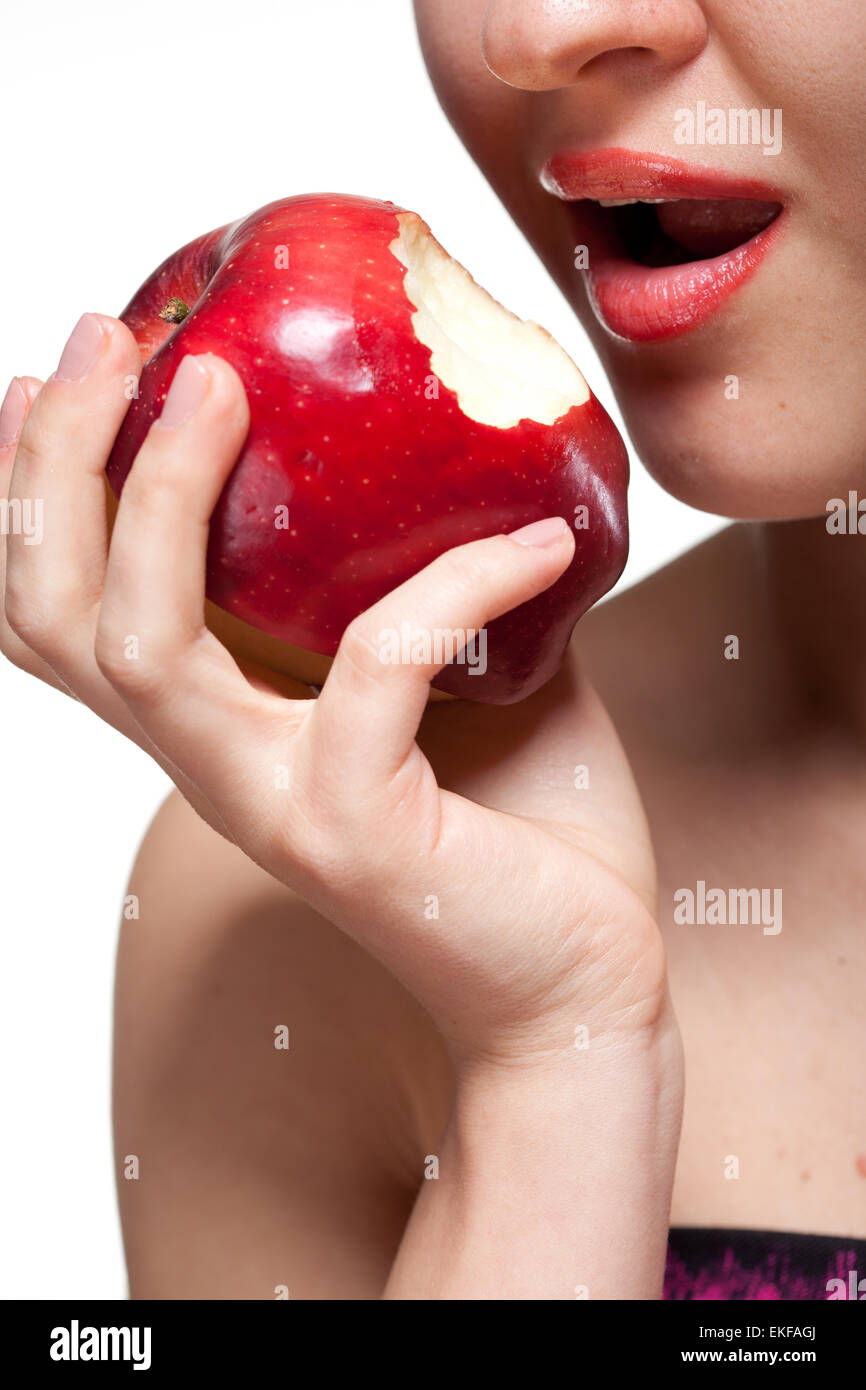 Junge Frau beißen roten Apfel, isoliert auf weiss Stockfoto