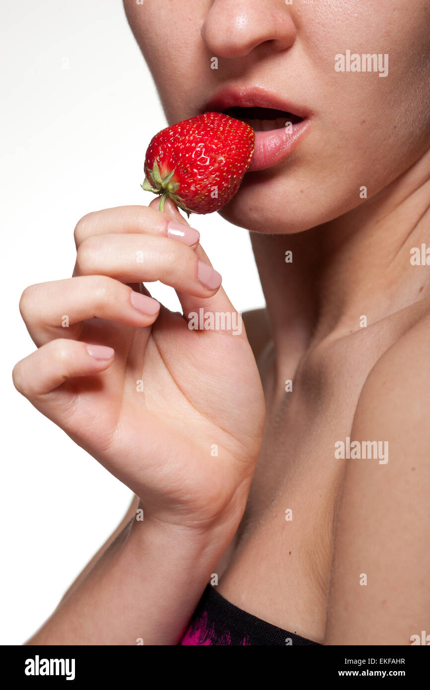 Junge Frau beißen Erdbeere isoliert auf weiss Stockfoto
