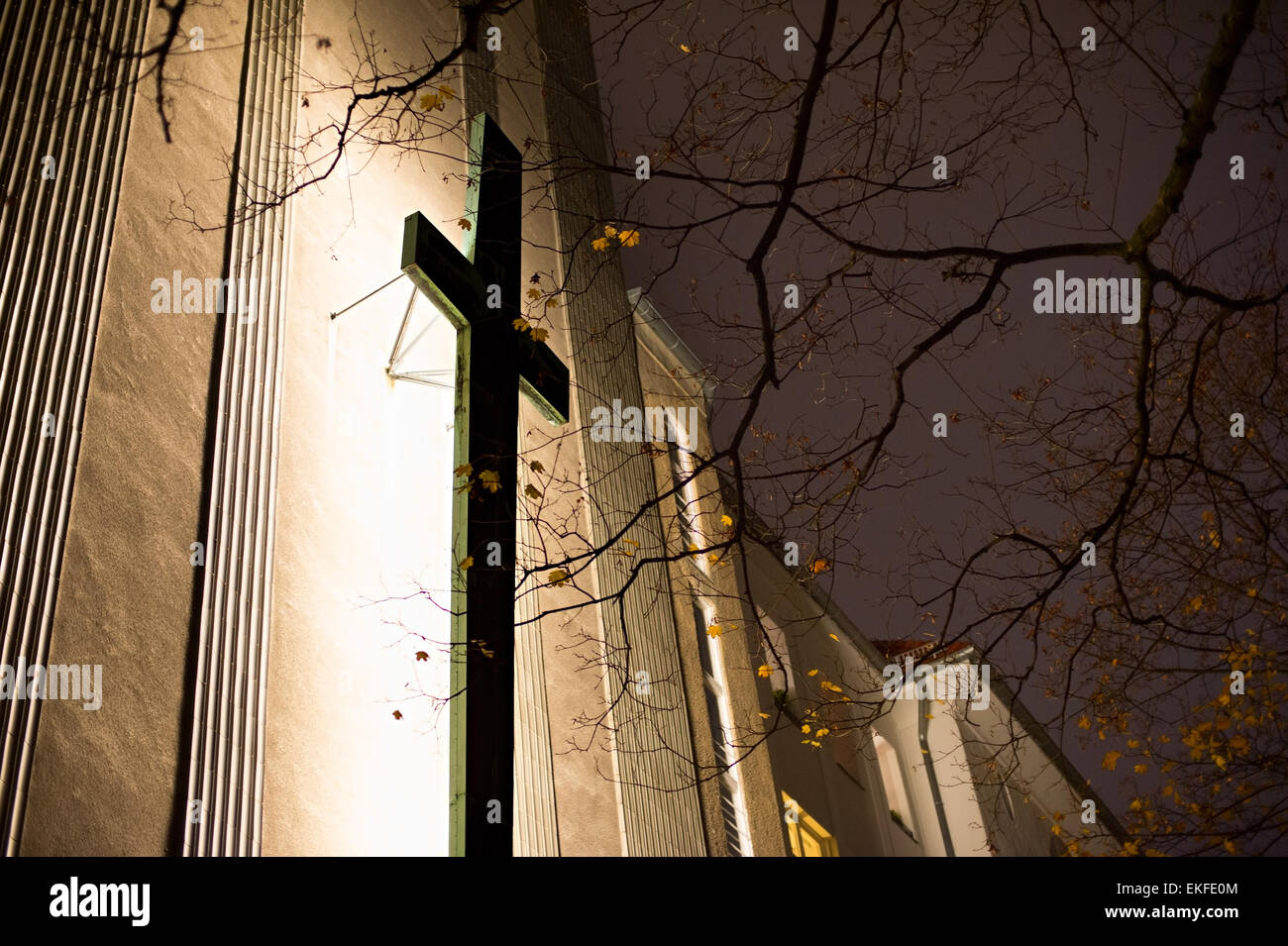 Kreuz auf der Kirchenmauer in der Nacht. Berlin, Deutschland Stockfoto
