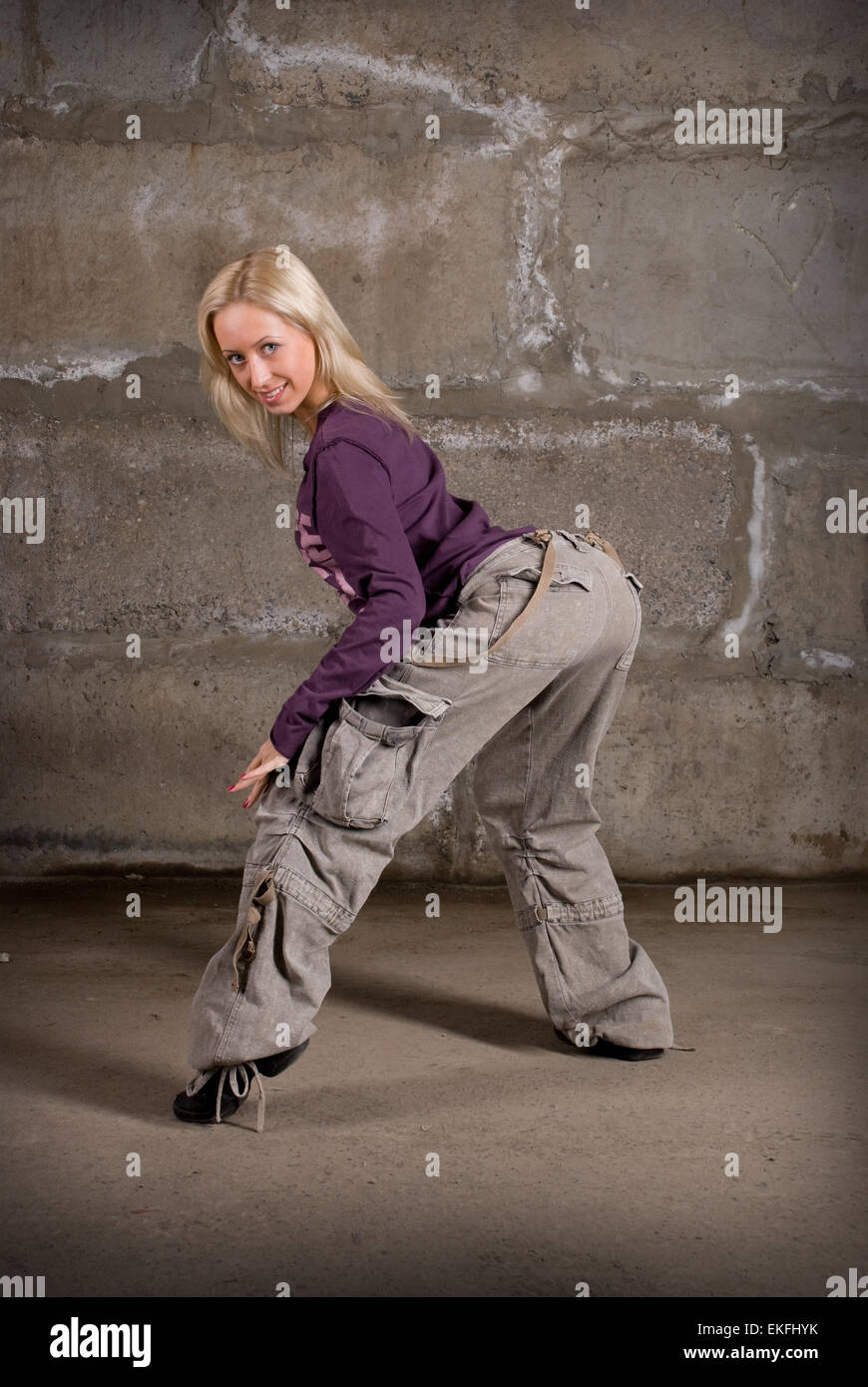 Schöne Hip-Hop-Mädchen tanzen über graue Mauer Stockfoto