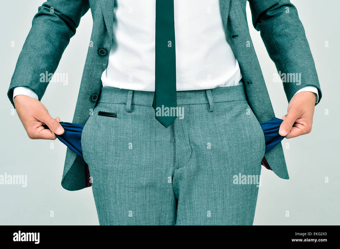 brach Geschäftsmann trägt einen grauen Anzug zeigt seine leeren Taschen Stockfoto