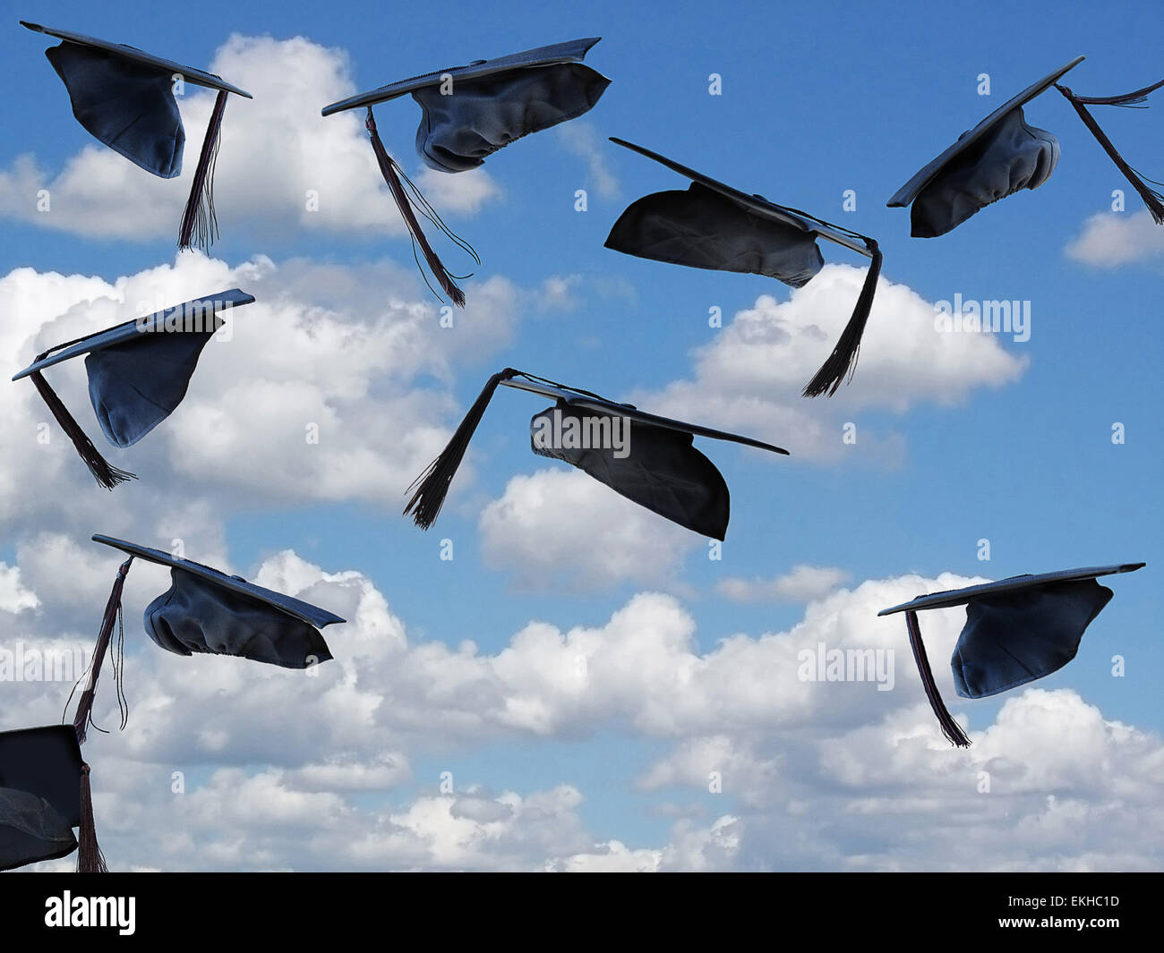 Schwarze Graduierung Hüte in der Luft im Sommerhimmel mit Wolken. Stockfoto