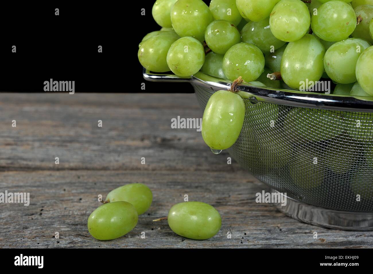Wassertropfen auf grüne Trauben in Metall Sieb. Stockfoto