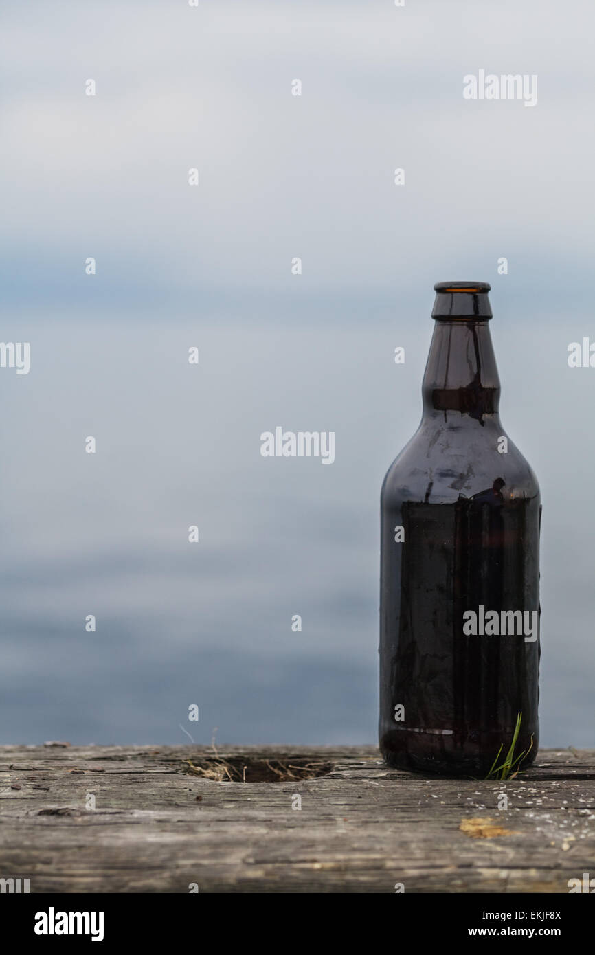 Geöffnete 500ml Flasche Bier auf alten rustikalen Holz in der Natur Stockfoto