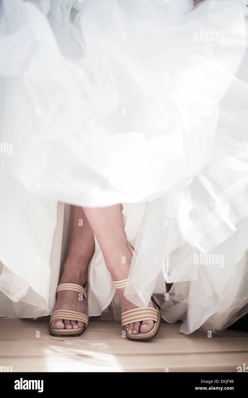 Gekreuzten Beinen eine Braut tragen ihre Hochzeitsschuhe Stockfoto