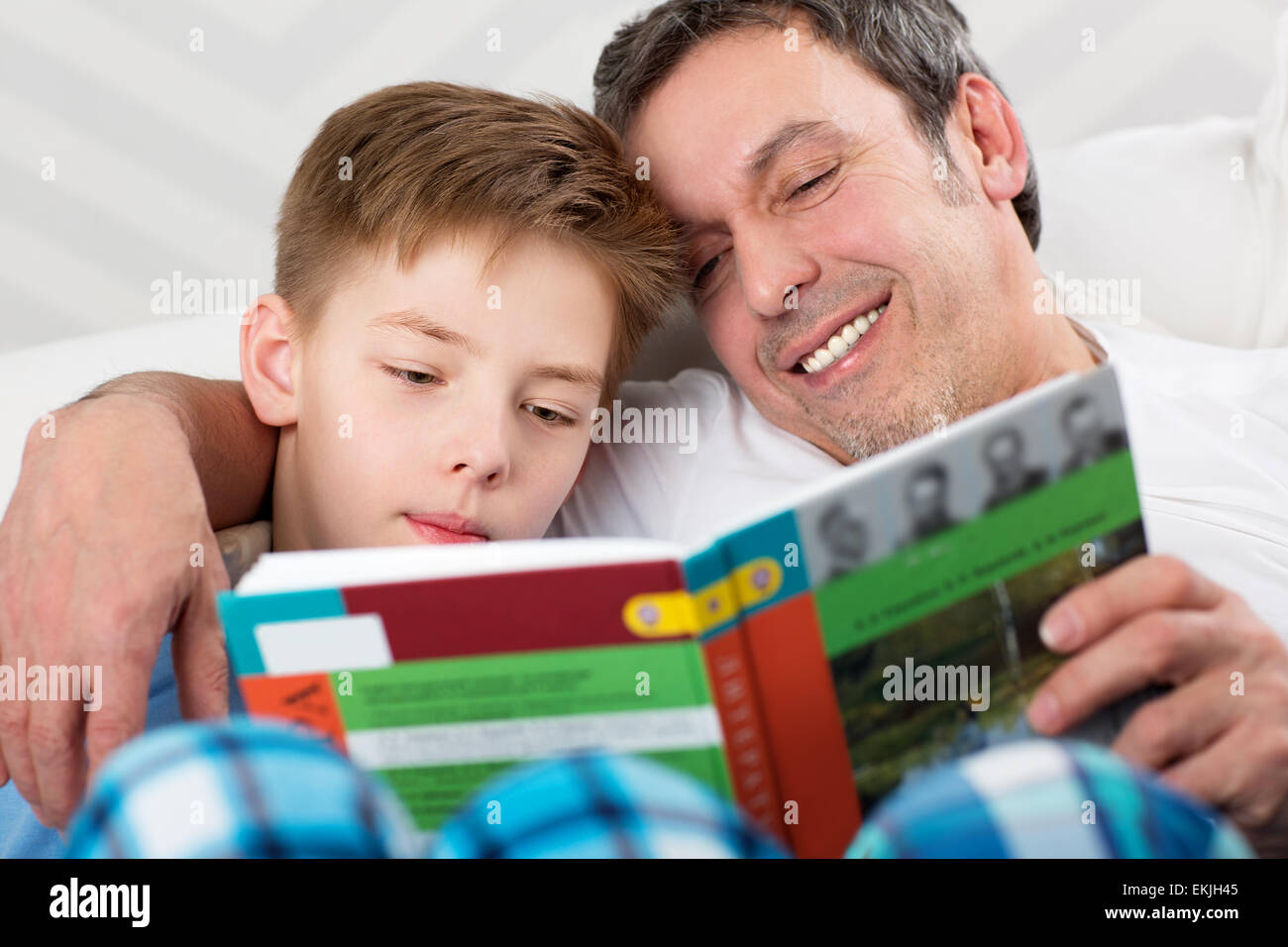 Vater und Sohn ein Buch zu lesen. Sorgfältige Vater Kind neue Dinge lernen zu helfen Stockfoto