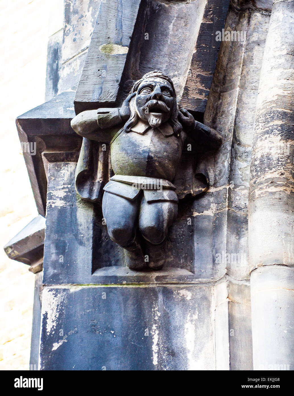 Ein Detail von einem erschrockenen Mann hielt seinen Kopf in seine Hände auf Seite Bogen von der mittelalterlichen Marktkirche in Hannover, Deutschland. Stockfoto
