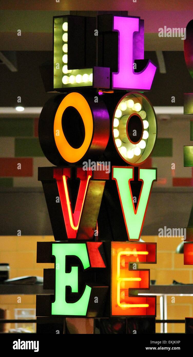 das Wort Liebe geschrieben in Neonlicht mit leuchtend bunten Farben Stockfoto