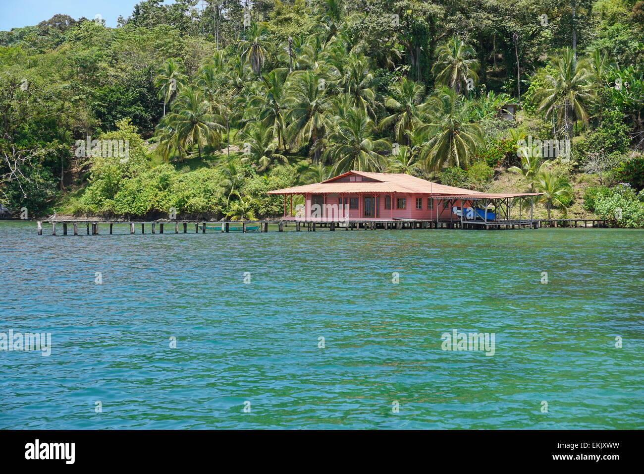 Üppige tropische Küste mit einem Haus und dock über das Wasser auf dem Archipel von Bocas del Toro, Panama Stockfoto