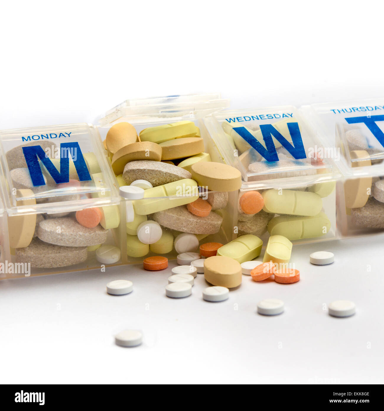 Pillen oder Ergänzungen zu verschütten aus einer vollgestopft wöchentliche Pillenbox Stockfoto