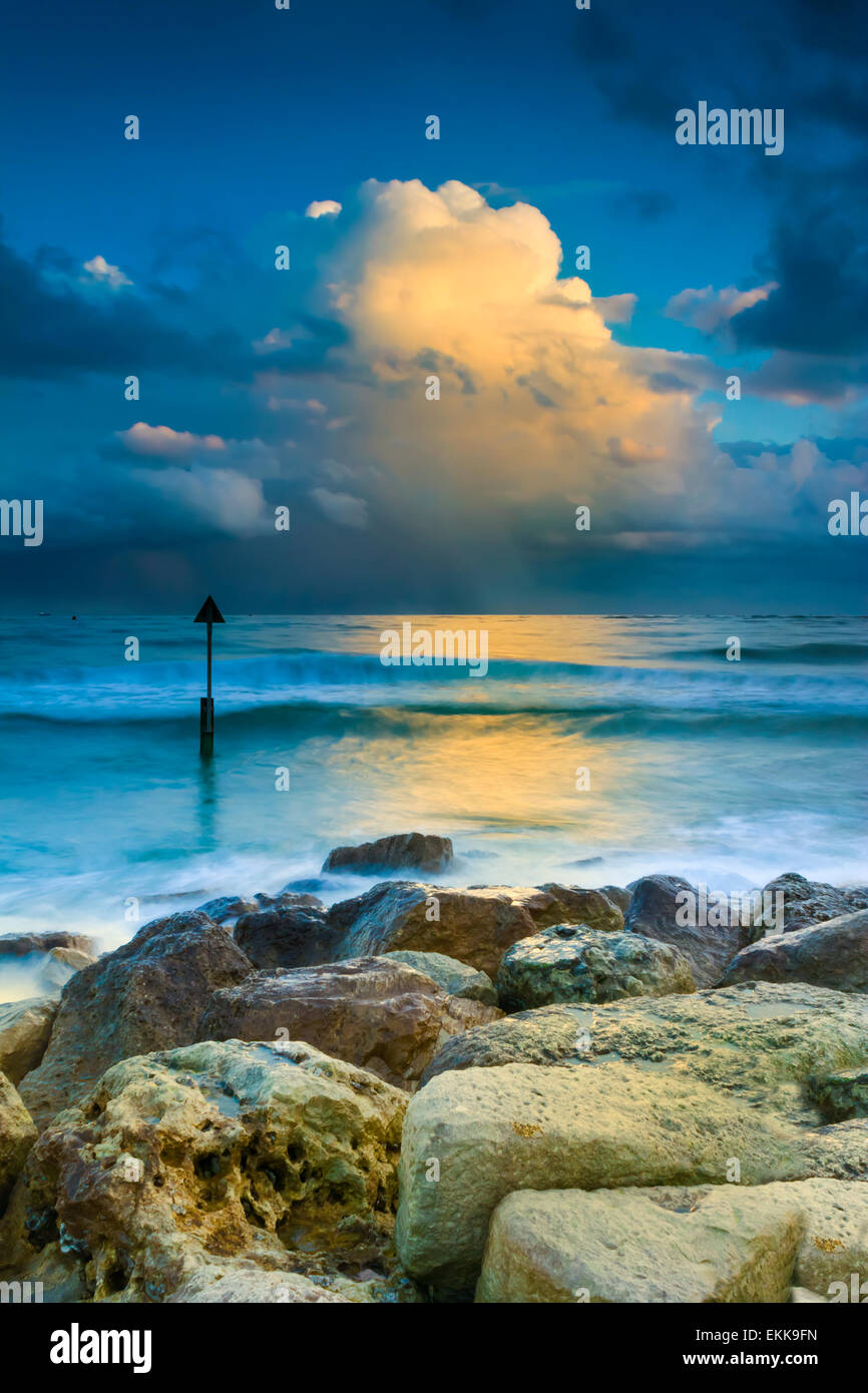 Regen-tragende Wolken hängen über den Horizont Casting Reflexionen in stehenden Gewässern vor der Küste von Dorset Stockfoto