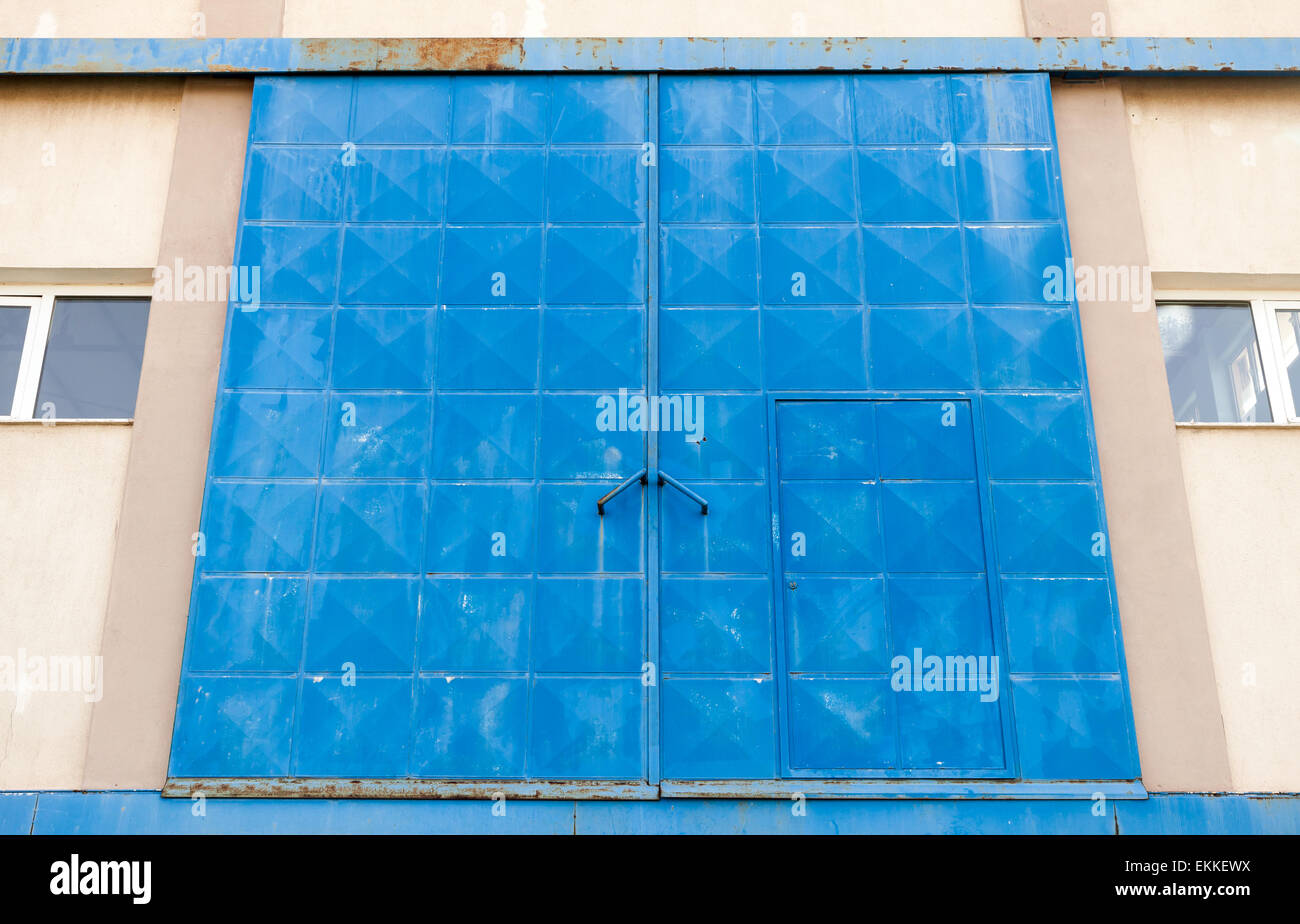 Großen blauen geschlossen Metalltor Industriegebäude, Foto Hintergrundtextur mit Perspektive Stockfoto