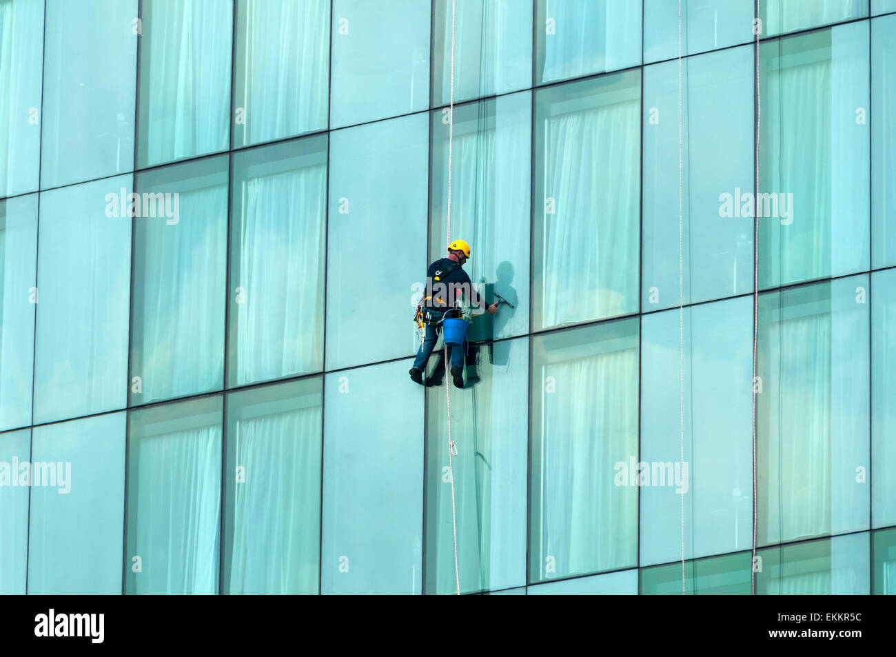 Fenster Reiniger aufgehängt an einem Seil auf der Beetham Tower, Deansgate, Manchester, England, UK Stockfoto