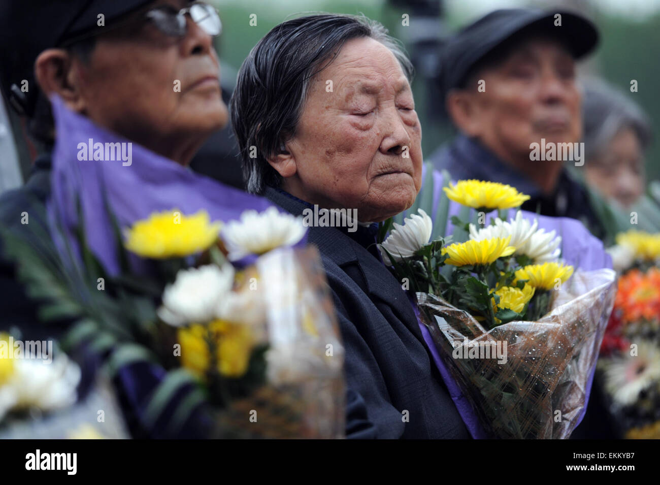 (150412)--Peking, 12. April 2015 (Xinhua)--Überlebende der Nanjing Massaker Xia Shuqin trauert um das Massaker von Nanjing Opfer vor der Wand eingeschrieben die Namen der Opfer in der Memorial Hall der Opfer im Massaker von Nanjing von japanischen Invasoren in Nanjing, der Hauptstadt der ostchinesischen Provinz Jiangsu, 5. April 2015. Japanische Truppen eroberte dann Chinas Hauptstadt Nanjing am 13. Dezember 1937 und begann ein 40-odd-Day-Gemetzel, bei dem mehr als 300.000 chinesische Soldaten, Arme und Zivilisten niedergelegt hatte getötet wurden, und mehr als 20.000 Frauen vergewaltigt wurden. (Xinhua/Han Yuqing) Stockfoto