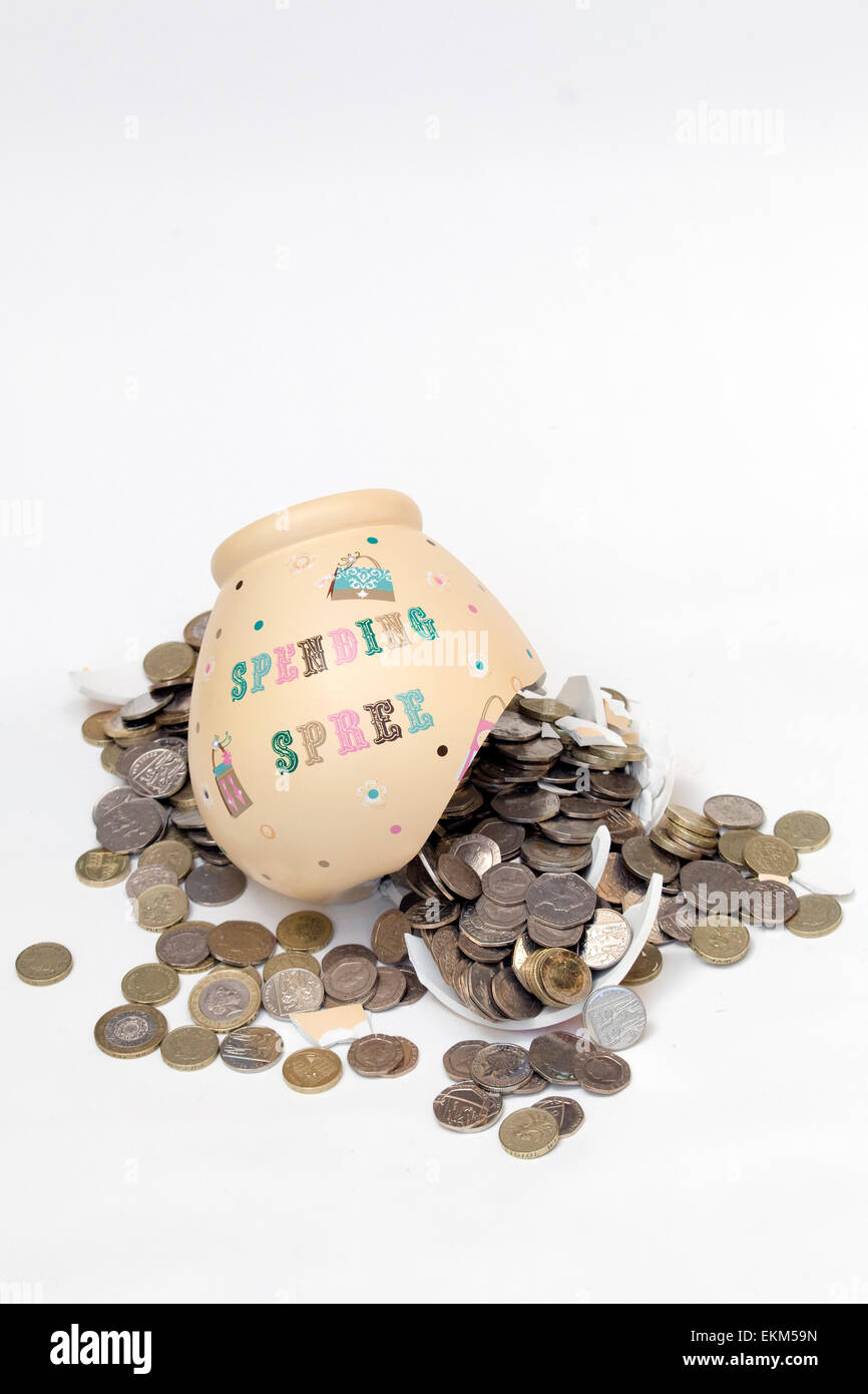 Zertrümmerte Spardose mit Münzen Gießen aus ihm heraus auf weißem Hintergrund Stockfoto