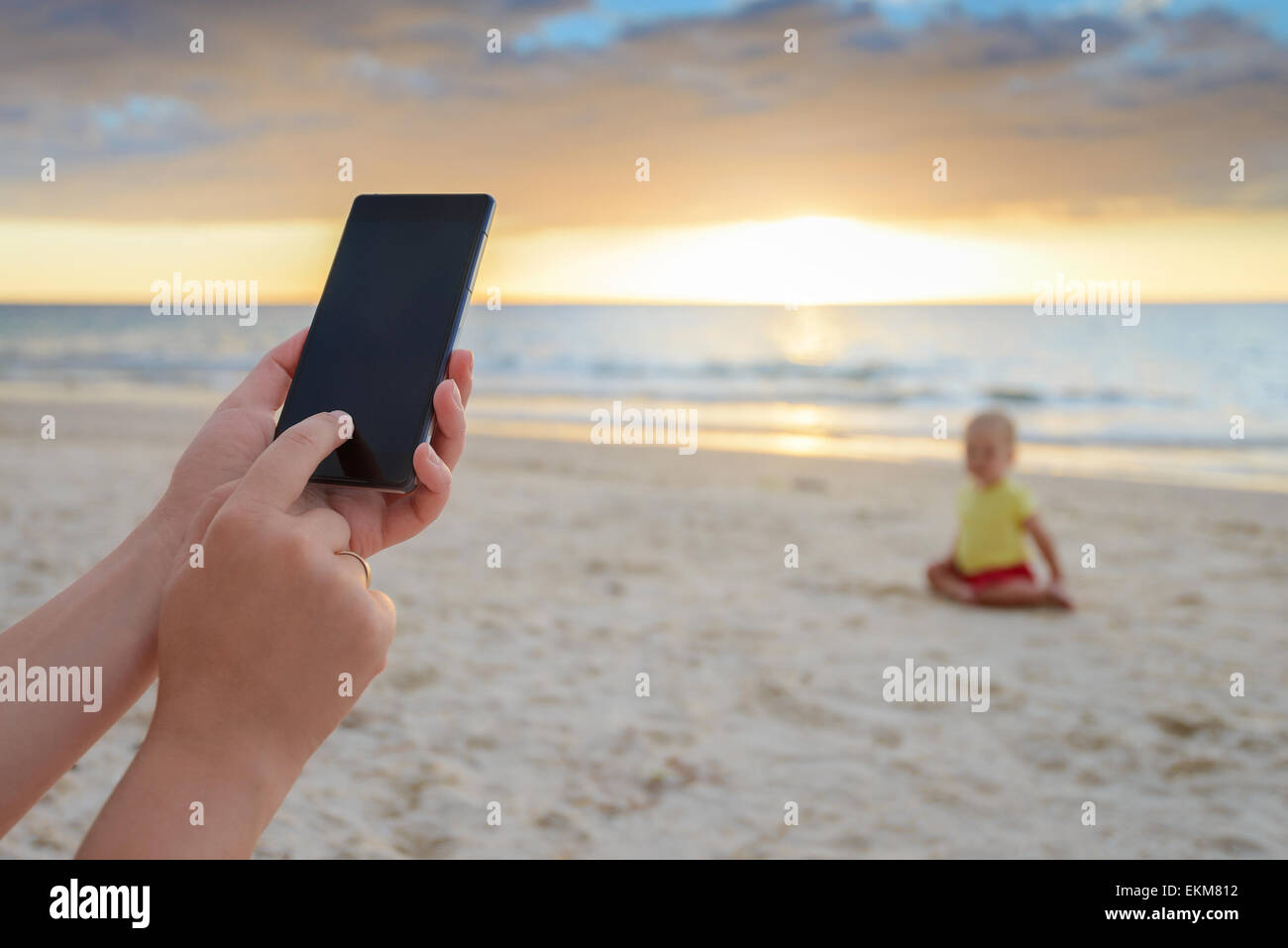 Frau ist ihr Sohn am Strand im warmen Sonnenuntergang fotografieren Stockfoto