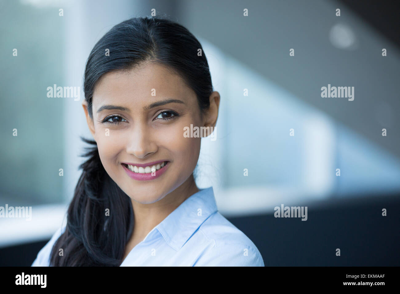 Closeup Portrait, junge professionelle, schöne selbstbewusste Frau im blauen Hemd, freundliche Persönlichkeit, lächelnd isoliert im Haus der Stockfoto