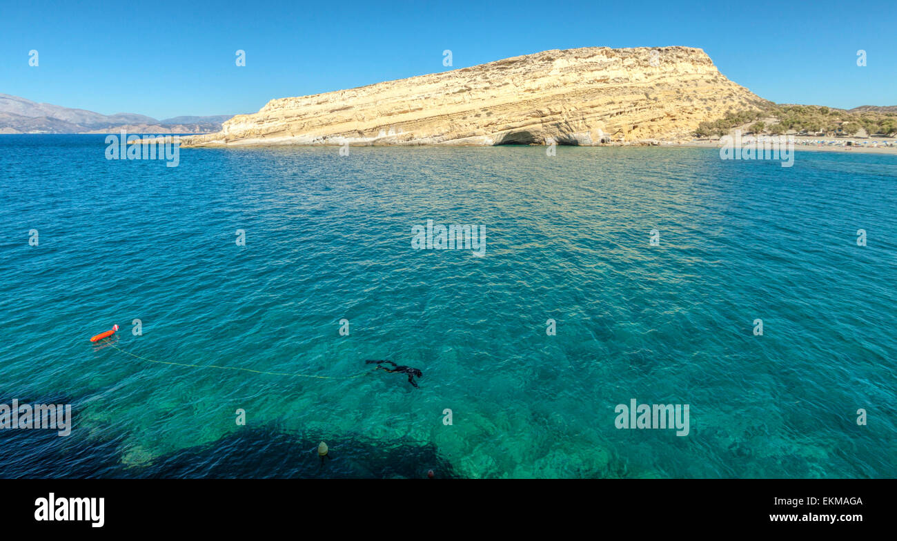 Taucher Schnorcheln in Türkis farbigen Bucht von Messara, Matala, berühmt für seinen Strand, Felsen und Höhlen, Kreta, Griechenland. Stockfoto