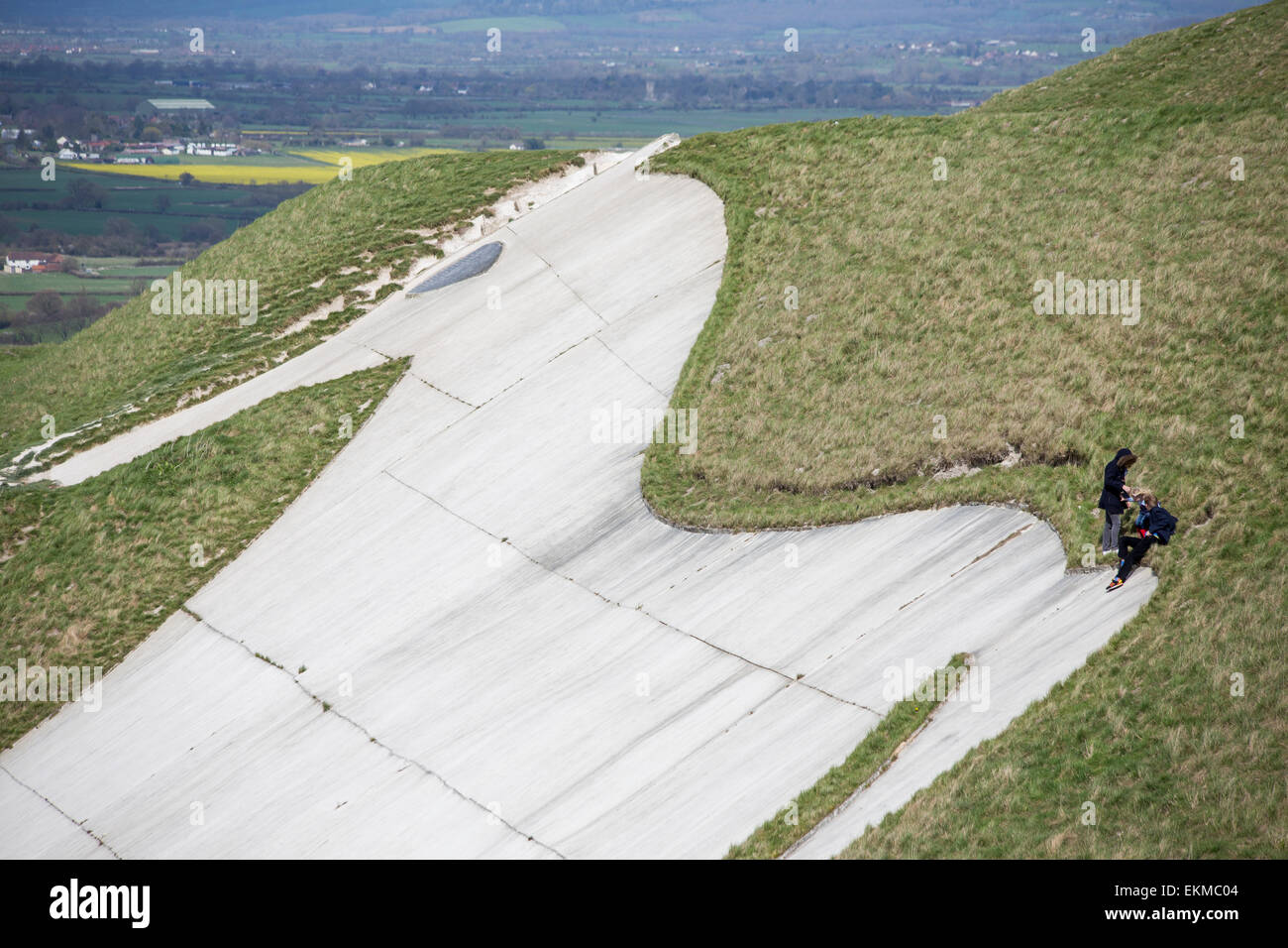 Wiltshire, UK. 12. April 2015. UK Wetter: Starke stürmischen Winde hoch auf das Wahrzeichen chalk White Horse oberhalb der Stadt Westbury. Die starken Winde nicht viele Mitglieder der Öffentlichkeit vom Besuch und die Nutzung des Wetters zu wandern, gehen Hunde, Drachen und genießen Sie die atemberaubende Aussicht über die Wiltshire Vale zu stoppen.  Die Site ist geschützt von English Heritage, die behaupten die alten Wallburg Eisenzeit saisonal dadurch, dass weidende Schafherden zu erhalten günstige Kreide Gräser und Pflanzen zu schrubben.   Bildnachweis: Wayne Farrell/Alamy Live-Nachrichten Stockfoto