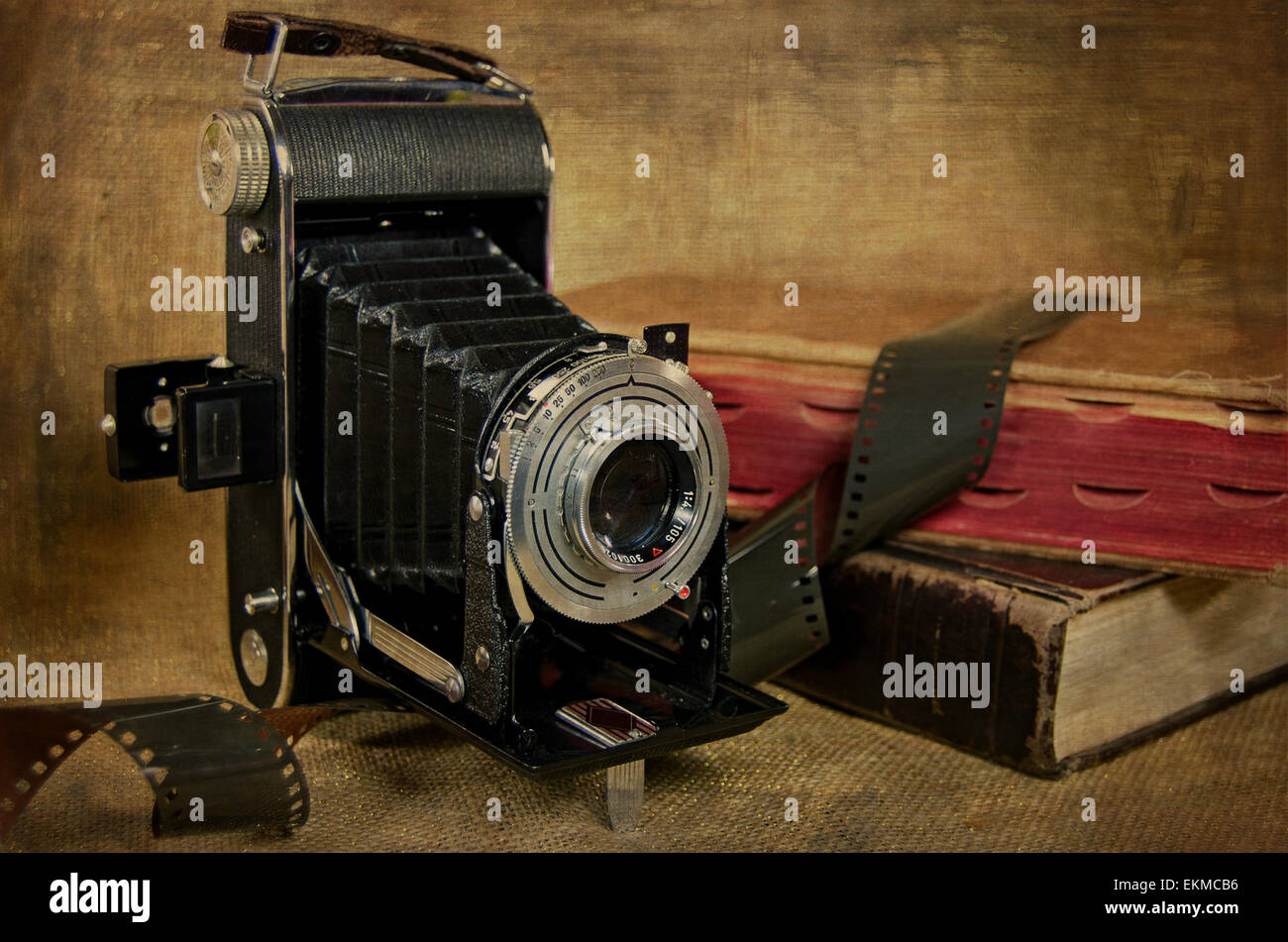 Vintage Balgenkamera, Film und alte Bücher mit Textur-Overlay. Stockfoto