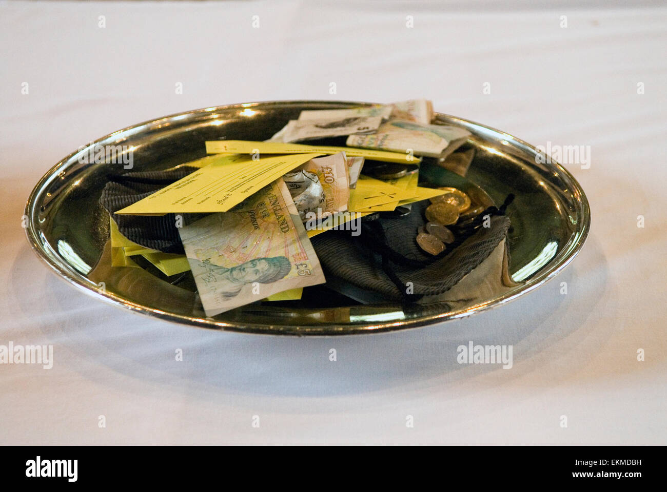 Church Collection Plate die Sammlung mit Papiergeldscheinen und einigen Münzen Church of England. Manche Leute legen ihren Beitrag in einen Umschlag, so dass der Betrag nicht mehr sichtbar ist. HOMER SYKES AUS DEN 2015 2010ER JAHREN Stockfoto