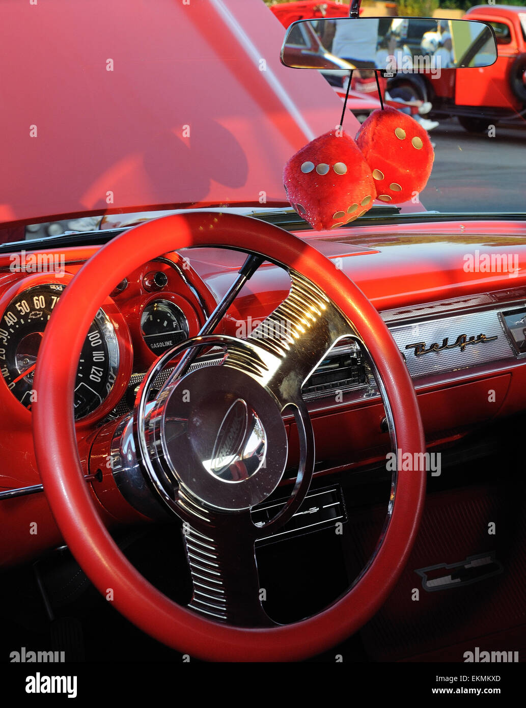 Roten fuzzy Dice hängen von einem Spiegel in einem 1957 Chevrolet. Stockfoto