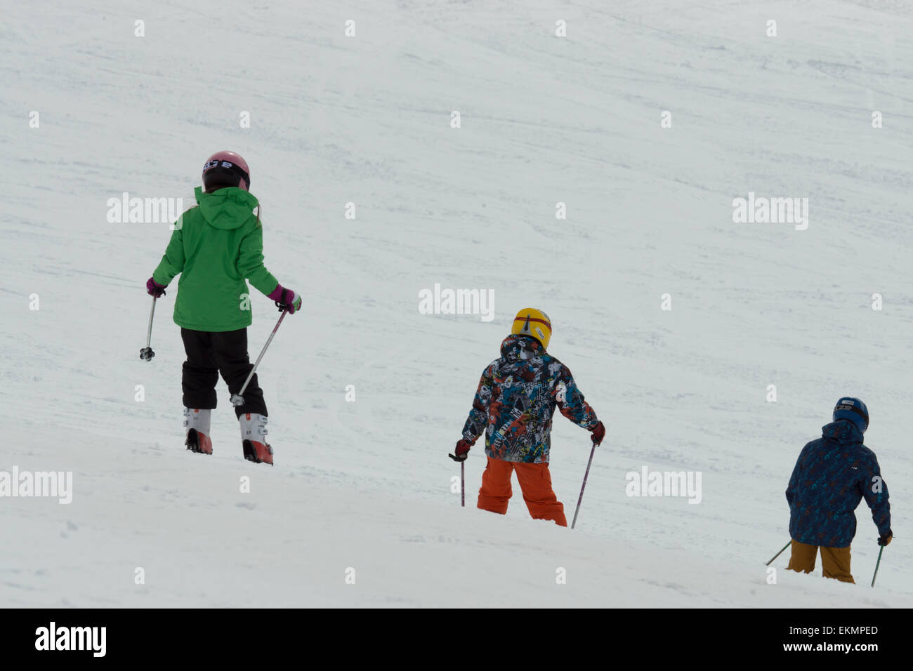 Drei 3 Freunde einander folgende lernen Skifahren Stockfoto
