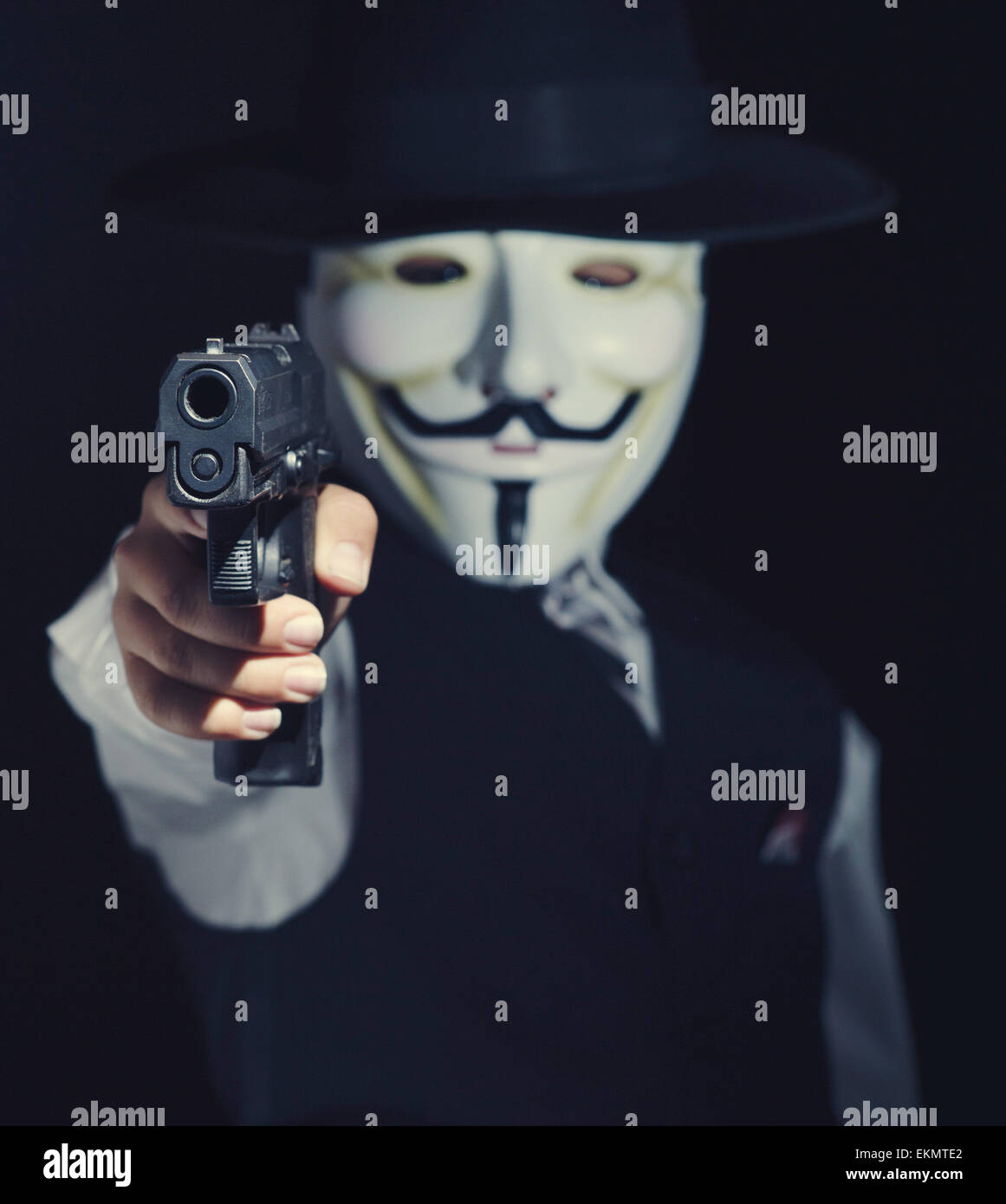 Person in anonymen Maske mit Pistole in der hand Stockfoto