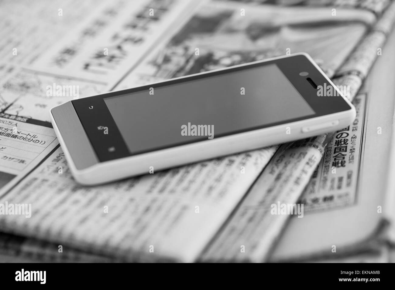 Stapel von Zeitungen mit Smartphone drauf Stockfoto