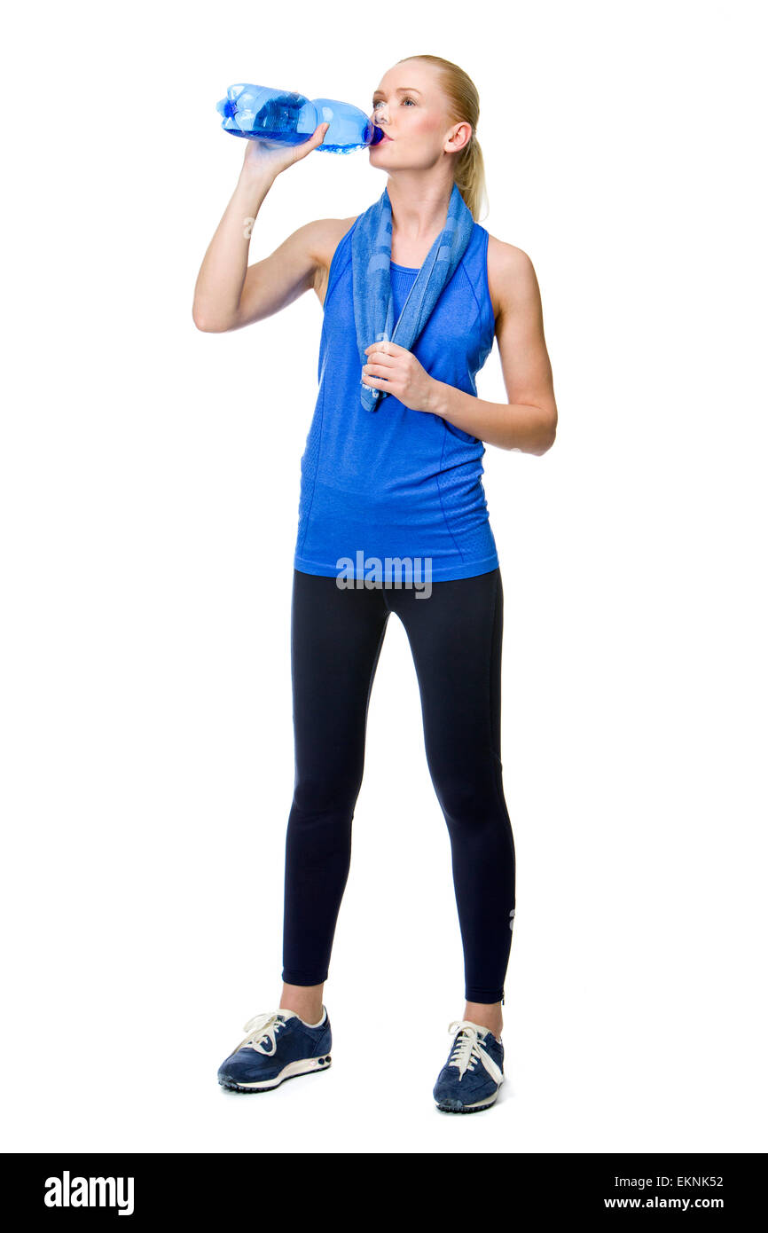 blonde Frau trägt Fitnesskleidung und Trinkwasser Stockfoto