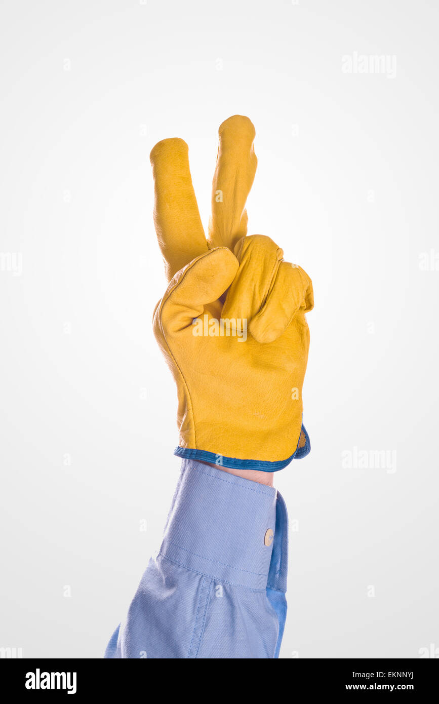 Bau-Ingenieur tragen gelb Leder schützende Handschuhe angehoben zwei Finger für V-Zeichen oder Voting Stockfoto