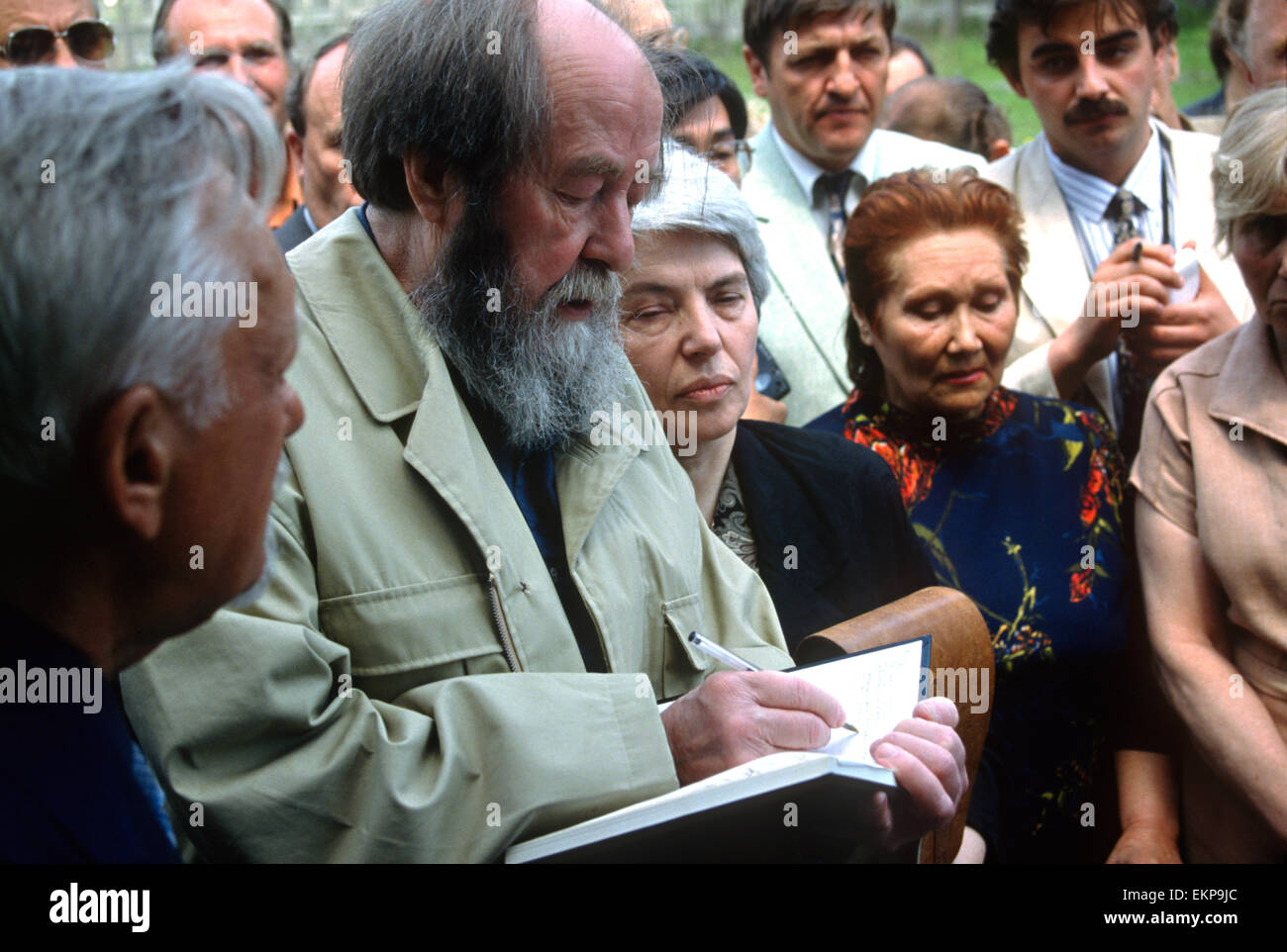 Russische Nobel Preis Schriftsteller Alexander Solzhenitsyn unterschreibt eine Kopie seines Buches nach der Ankunft mit dem Zug zurück in seine Heimat wie seine Frau sieht Alya Svetlova auf 5. Juni 1994 in Chabarowsk, Russland. Solschenizyn wurde nach dem Fall der Sowjetunion kehrte aber 1974 aus der Sowjetunion ausgewiesen. Stockfoto