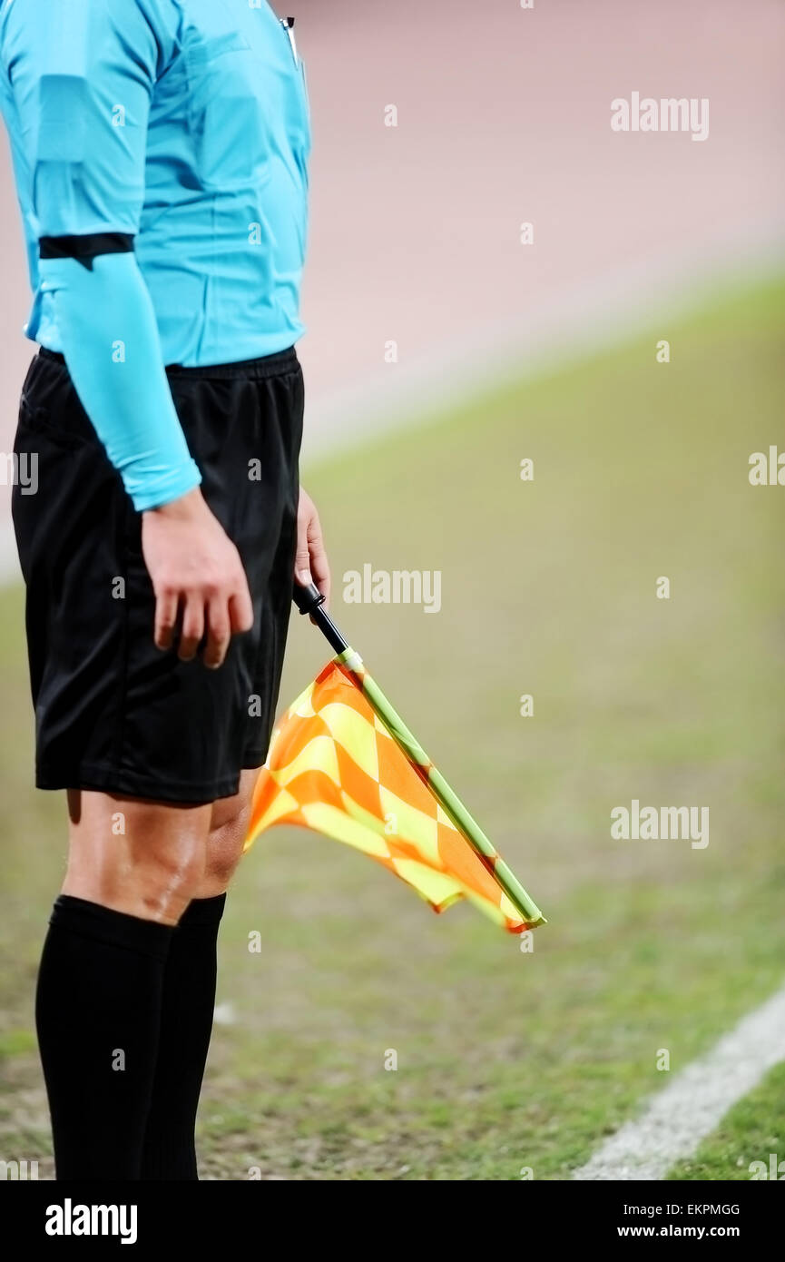 Schiedsrichter-Assistenten mit der Flagge an der Seitenlinie während eines Fußballspiels Signalisierung Stockfoto