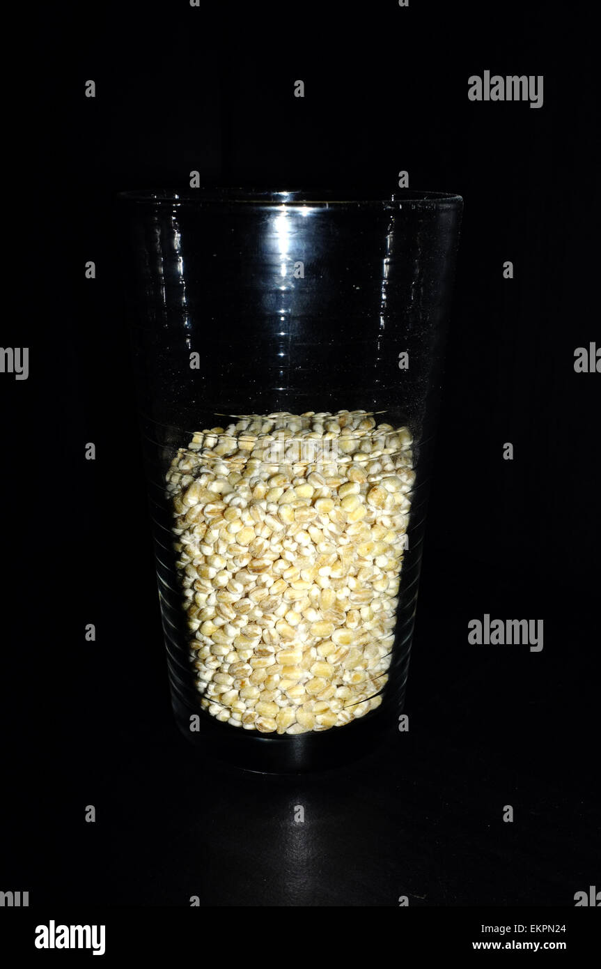 Ein Glas halb voll/halb vor einem schwarzen Hintergrund fotografiert leeren. Stockfoto