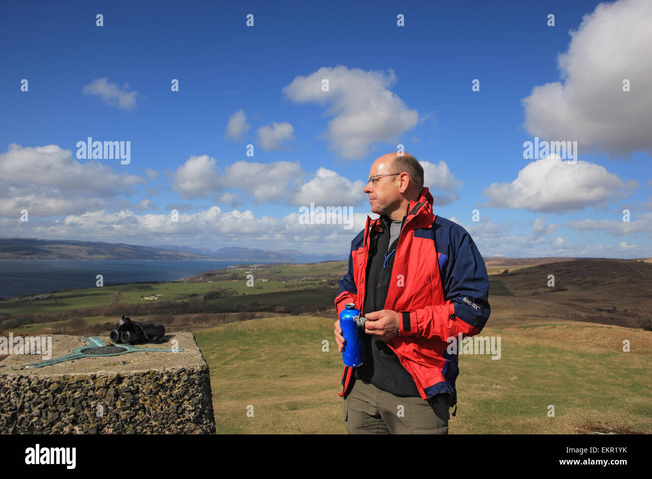 Mann mit einem Drink auf dem Gipfel des Knock Hill in der Nähe von Largs in Ayrshire, Schottland Stockfoto