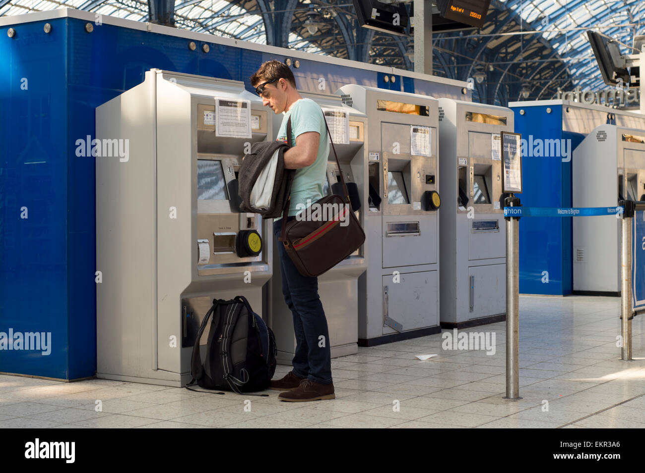 Pendler, die von den Self-Service-Automaten am Bahnhof von Brighton ein Bahnticket kaufen Stockfoto