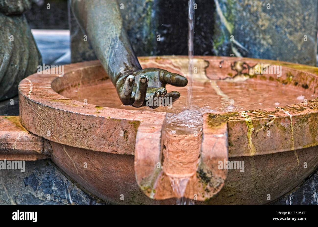 Ein Springbrunnen in einem Stadtpark in Cordoba. Auf einem farbigen Hintergrund jedoch unscharf Spritzwasser nach dem Zufallsprinzip die Hände der Bronze Figuri abprallen Stockfoto