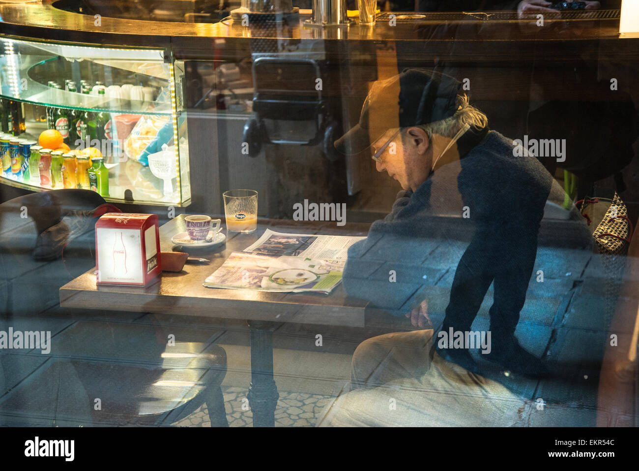 Ein Mann liest eine Zeitung in einer bar Stockfoto