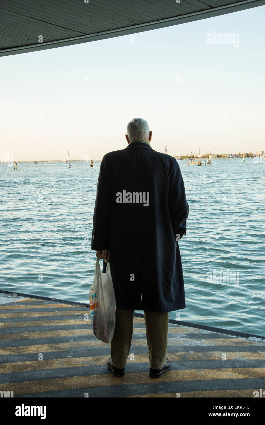 Ein Mann der Vaporetto warten in einem Boot Stop in Venedig Stockfoto