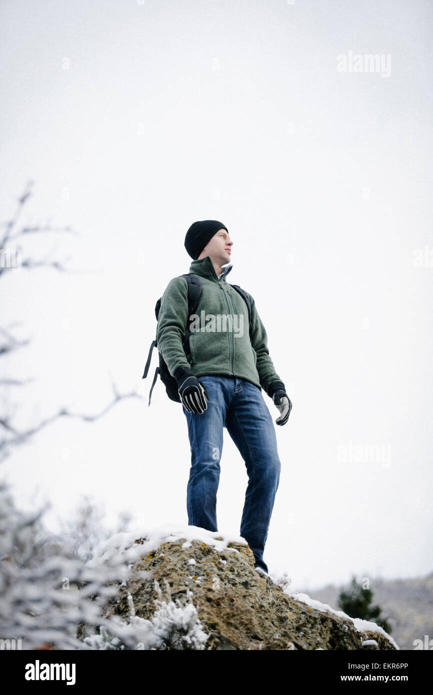 Ein Mann trägt einen Fleece-Jacke und Hut, einen Rucksack tragen. Stockfoto