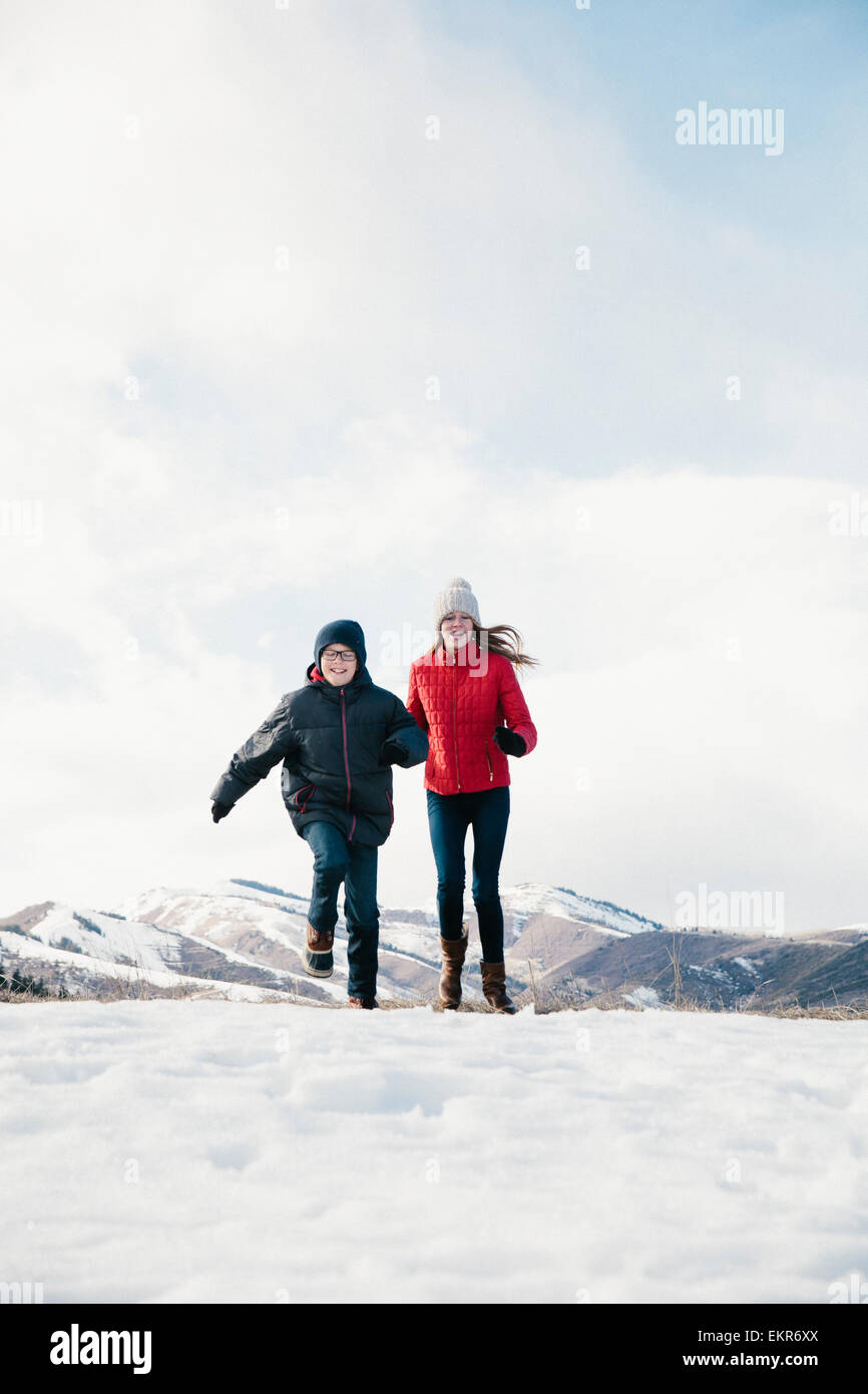 Zwei Kinder, Bruder und Schwester, die quer durch des Schnees. Stockfoto