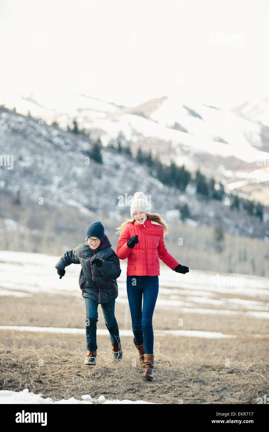 Bruder und Schwester zusammen laufen über den Rasen n Winter. Stockfoto