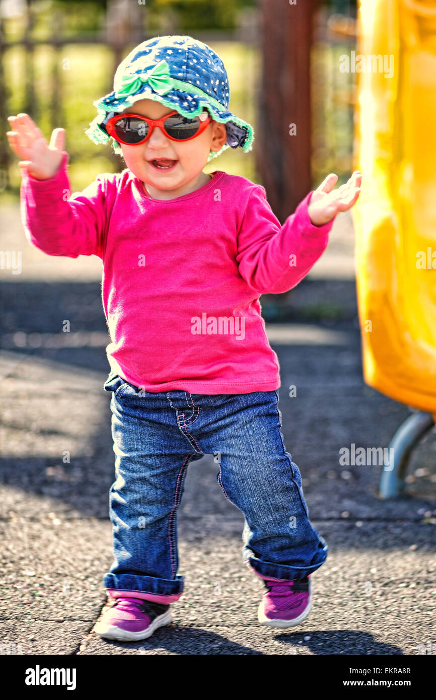Ein hübsches kleines Mädchen mit roter Brille und blauen Hut Spaß Stockfoto