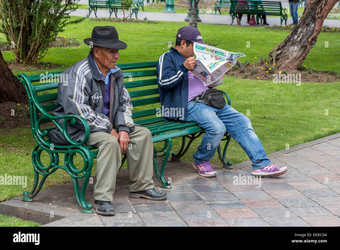 Peru, Cusco.  Peruaner ruht auf den Bänken in der Plaza de Armas. Stockfoto