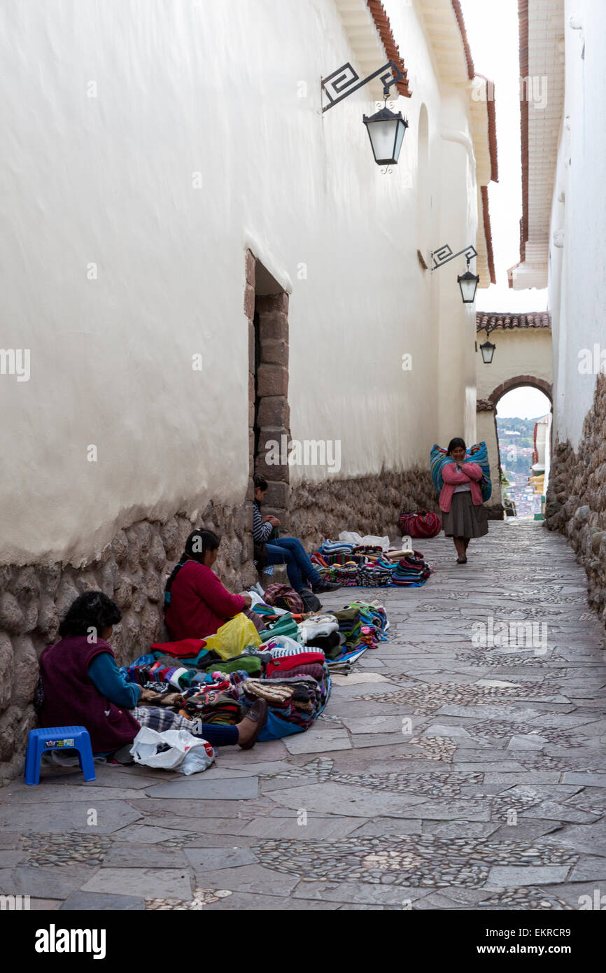 Peru, Cusco. Quechua Frauen verkaufen gestrickt von Artikeln in einer Straße oberhalb der Plaza de Armas. Stockfoto