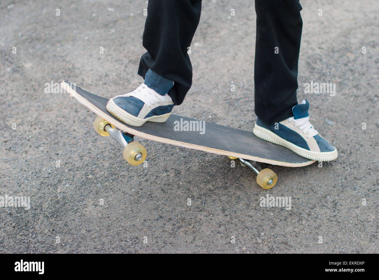 Skateboarder reitet auf dem Bürgersteig. Stockfoto