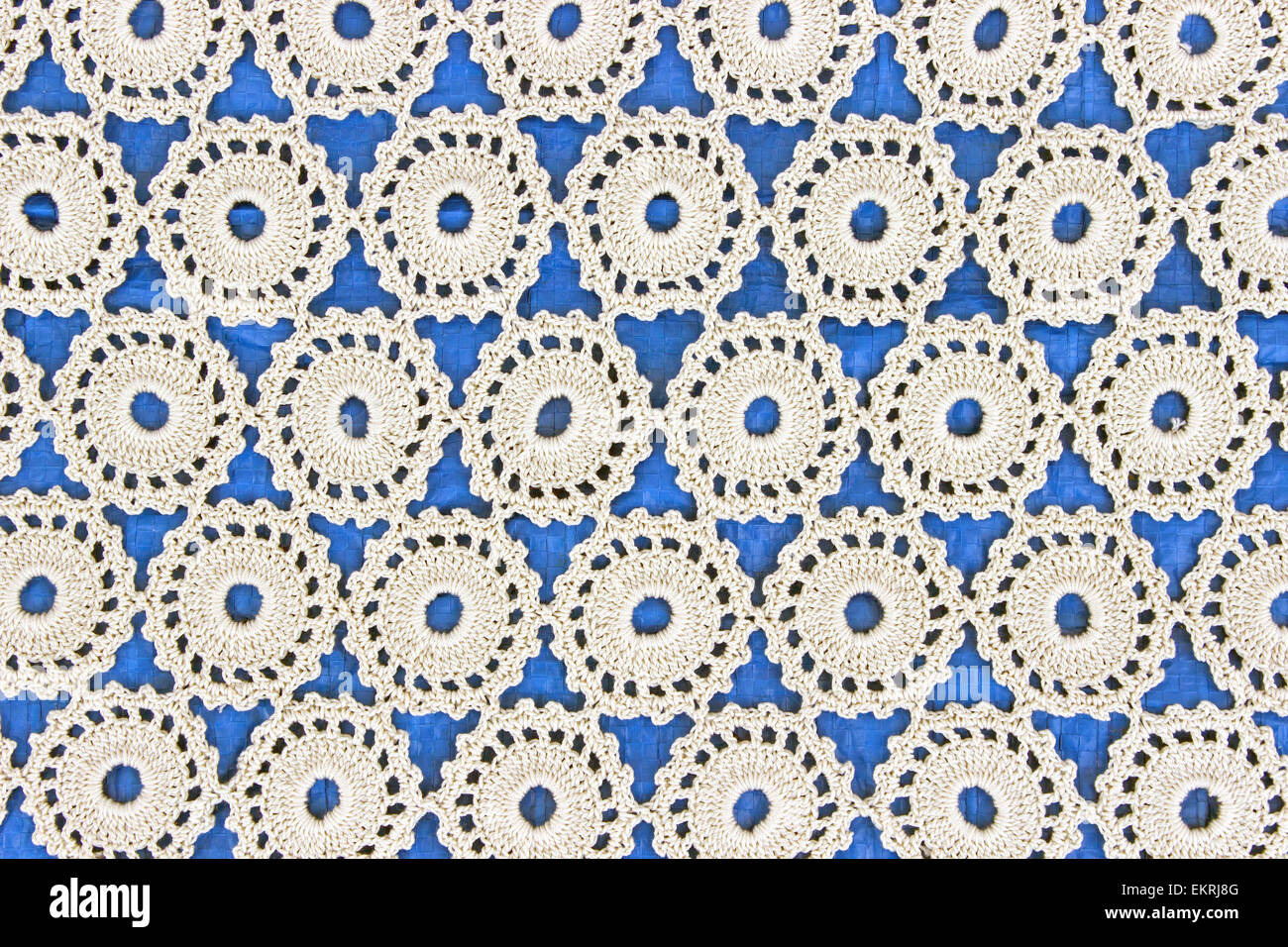 Handgemachte weiße Spitze auf blauem Hintergrund Stockfoto