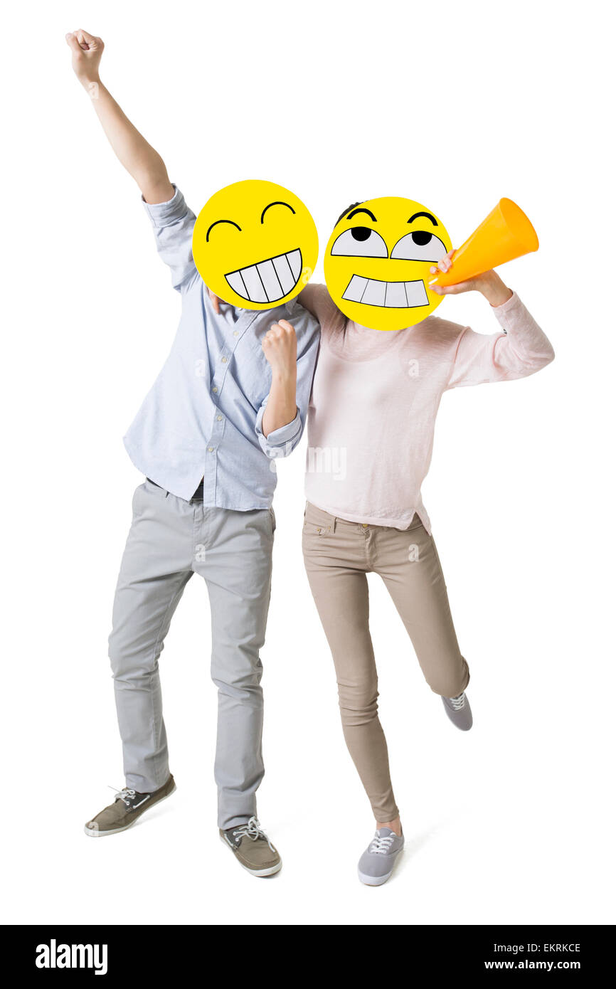 Junges Paar mit zwei happy Emoticon Gesichtern vor der ihre Gesichter jubeln Stockfoto