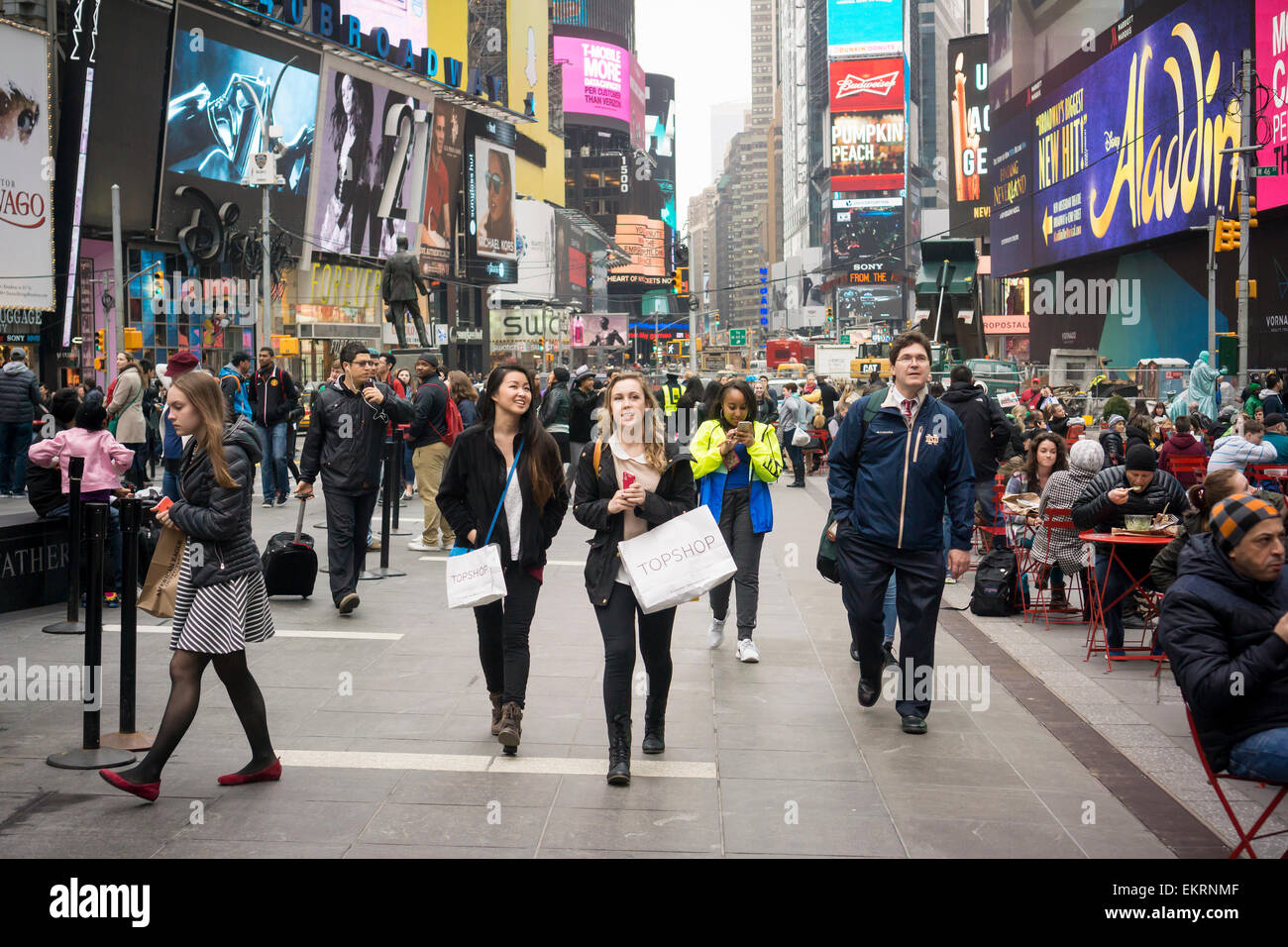 Touristen mit ihren Käufen auf dem Times Square in New York am Freitag, 10. April 2015. Ein starker Dollar macht es weniger attraktiv für New York zu besuchen (und Geld!) eventuell schneiden in der Tourismusbranche tätig. Der Tourismus-Branche generiert $ 60 Milliarden Dollar in die Wirtschaft New York gehen. 55 Millionen Menschen besuchten die Stadt letztes Jahr mit 22 % in den letzten zehn Jahren springen Arbeitsplätze im Tourismus.  (© Richard B. Levine) Stockfoto