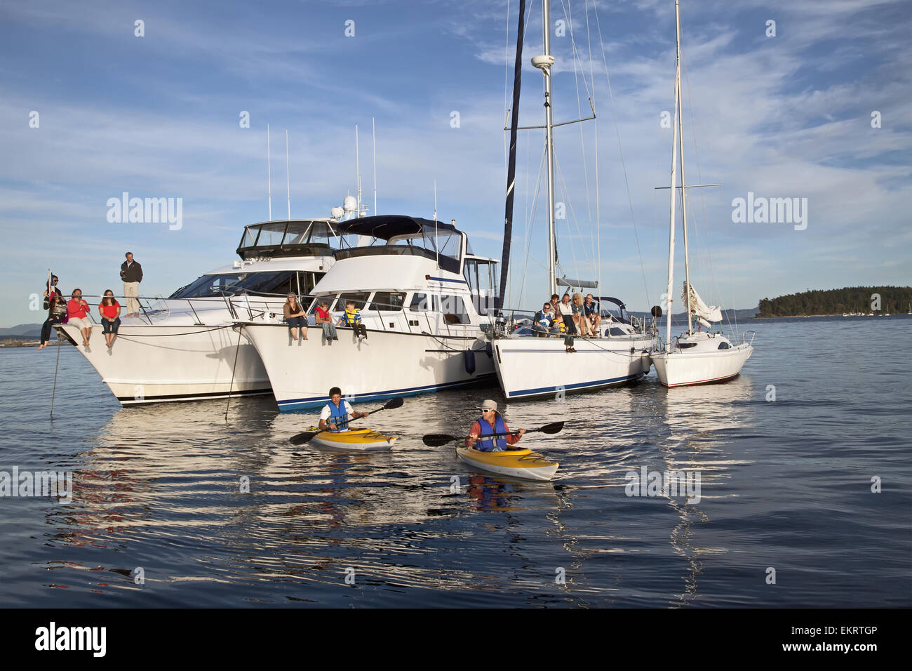 Kajakfahrer pass eine Flottille von Motorboote und Segelboote Autobahnabfahrt Sidney Insel; Sidney, British Columbia, Kanada Stockfoto